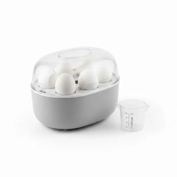 Camry CR 4482 egg boiler with eggs in the tray, measuring cup, and piercing needle.