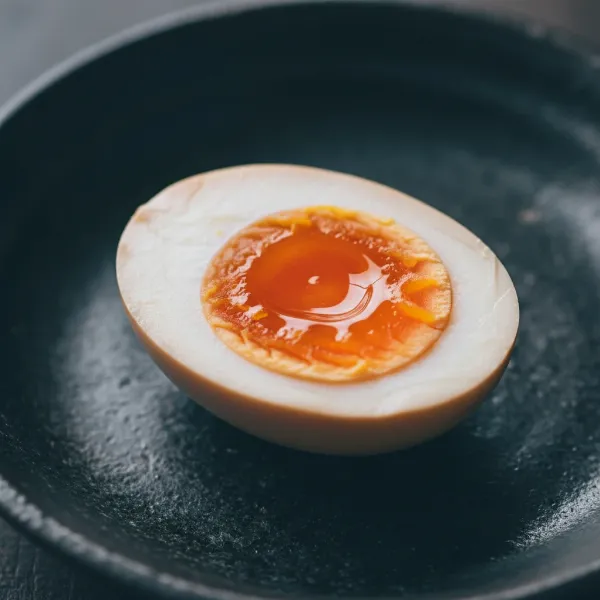 Close-up of a perfectly halved ramen egg with a jammy yolk, ready to be served.
