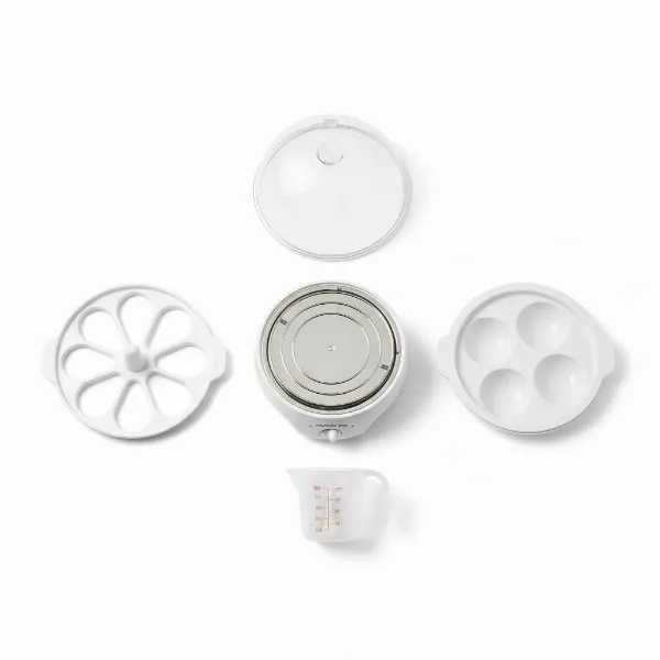 Proctor Silex Model 25501A egg cooker disassembled, showing base, egg tray, poaching tray, lid, and measuring cup with piercer.